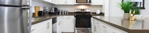 a kitchen with white cabinets and stainless steel appliances