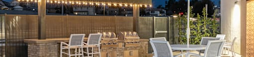 a patio with a bar and tables with chairs and umbrellasat Westbury Apartments, Rancho Cucamonga