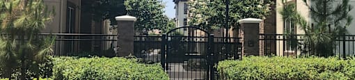 an apartment building with a gate and a sidewalk