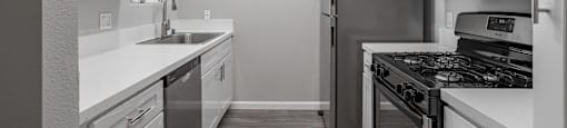 an empty kitchen with a wood floor and white wallsat Lincoln Park Apartments, Corona, 92882