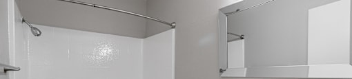 A white bathroom with a toilet, sink, and shower.