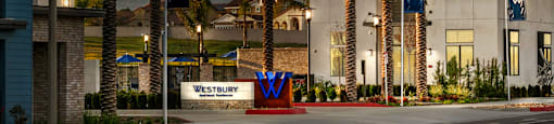 a city street with palm trees and a building with mountains in the backgroundat Westbury Apartments, Rancho Cucamonga, California