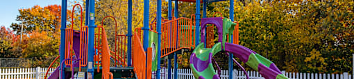 A playground with a blue roof and a purple slide.