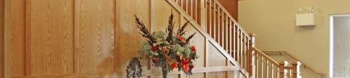 a wood paneled stairway with a table with a vase of flowers on it