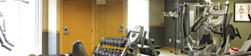 a fitness room filled with exercise equipment and weights
