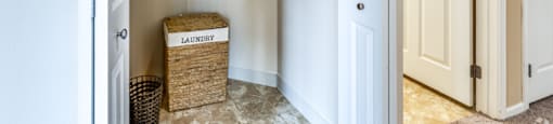 a hallway with two doors and a basket on the floor