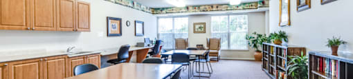 a community room with tables and chairs and a library