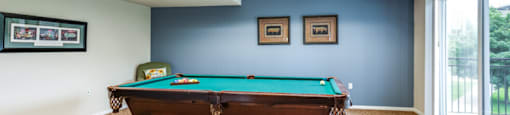 a pool table in a room with a window