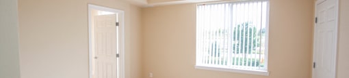 an empty bedroom with a large window