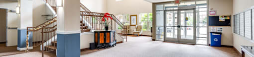 the lobby of a community center with stairs and a lobby door