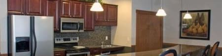 community room kitchen with a counter and chairs and a refrigerator