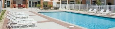 a swimming pool with chaise lounge chairs and umbrellas