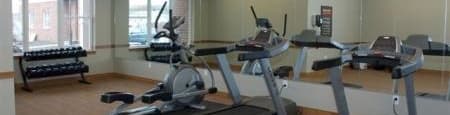 a fitness room with treadmills and other exercise equipment