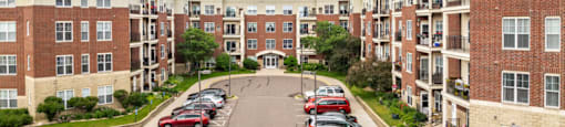 an aerial view of an apartment complex with cars parked on the street