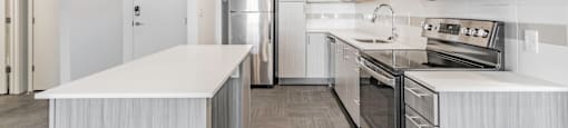 One and two Bedroom Apartment Homes with Large Kitchens with ample storage and light cabinets, quarts countertops and stainless steel appliances at Pinnacle Heights Apartments in Rogers, Arkansas