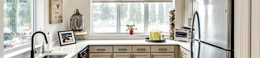 Clubhouse Kitchen with white cabinets and a stainless steel refrigerator at Legacy Commons Apartments in Omaha, NE