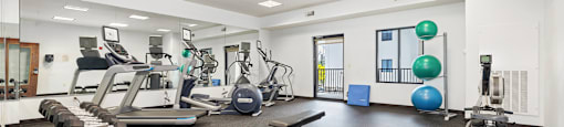 a gym with cardio machines and weights on the floor