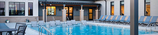 A pool area with a sun lounger and a table.