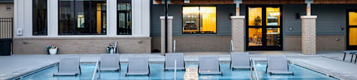 A pool in front of a building with a logo on it.