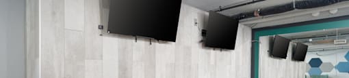 a games room with a shuffleboard table and two televisions