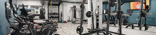 a spacious fitness room with cardio machines and weights