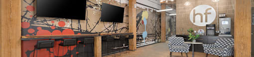 a large open space with wood floors and a mural on the wall