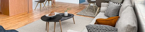 an open living room and kitchen area with a couch table and chairs and a kitchen with a