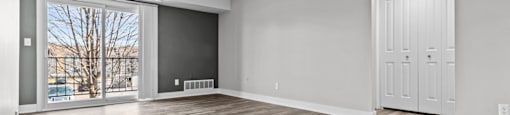 A room with a wooden floor and a white door.