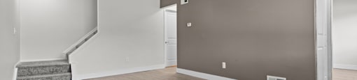 A room with a staircase and a wall-mounted air conditioner unit.