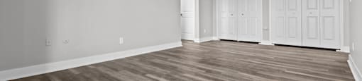A room with wooden flooring and white walls.