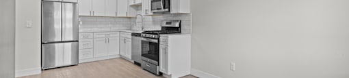 A kitchen with white cabinets and stainless steel appliances.