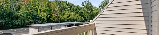 the deck of a home with a view of a yard and trees