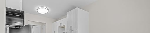 A kitchen with white cabinets and a wooden floor.