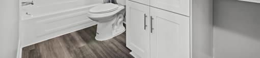 A white bathroom with a toilet, sink, and bathtub.