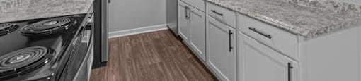 the kitchen in a new home with white cabinets and granite counter tops
