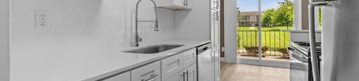 A kitchen with white cabinets and a black fridge.