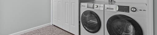 a washer and dryer in a laundry room with a white closet