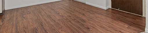 an empty living room with wood flooring and a ceiling fan