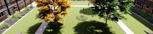 A tree with yellow leaves is in the middle of a courtyard.