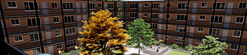 A tree with yellow leaves is in the courtyard of a building.