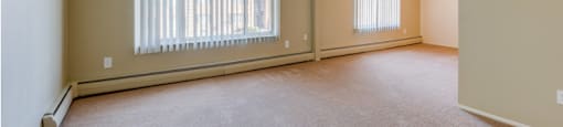 the living room of an empty house with large windows