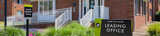 a leasing office sign in front of a brick building