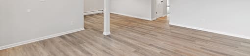 A room with wooden flooring and white walls.