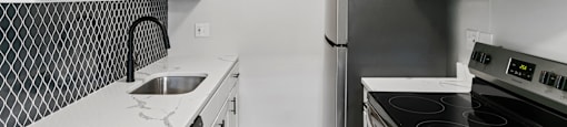 A kitchen with black and white appliances and cabinets.