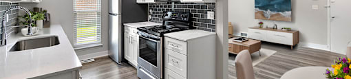 A modern kitchen with a refrigerator, oven, and sink.