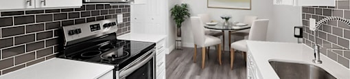 A modern kitchen with white cabinets and a black stove top.