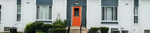 A white house with a black roof and a red door.