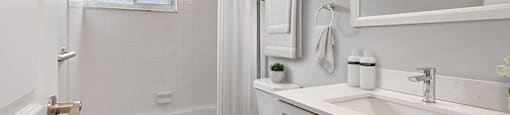 A white bathroom with a toilet, sink, and bathtub.