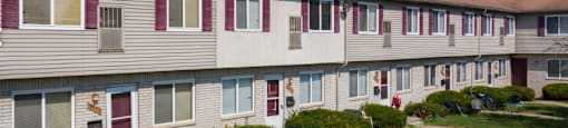 Apartment building with a red door and a blue lawn chair.