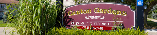 A sign for a place called Caronon Gardens with a phone number on it.